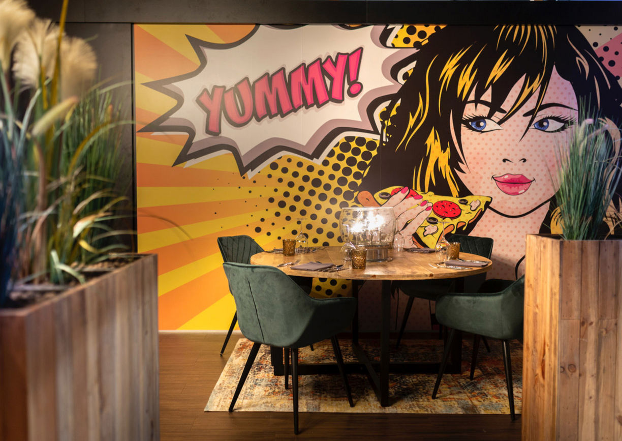 Blick auf gedeckten Tisch mit großem Pop Art Bild an der Wand