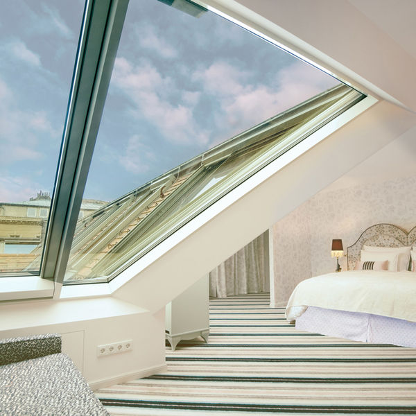 Suite im The Leo Grand Wien im Dachgeschoss mit Doppelbett und Sicht auf den Stephansdom