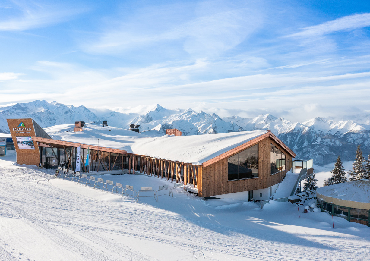 Blick auf Restaurant mitten in verschneiter Berglandschaft im Skigebiet Schmittenhöhe